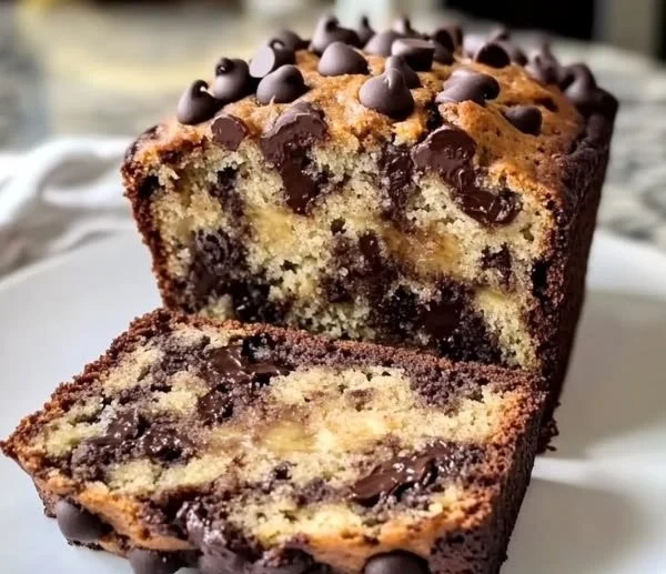 Freshly baked super moist chocolate chip banana bread sliced on a wooden board